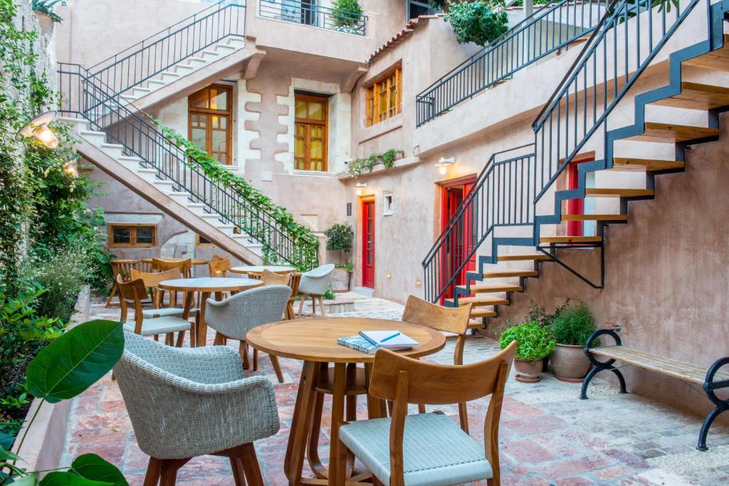 a patio with tables and chairs and stairs at Hotel Off in Chania