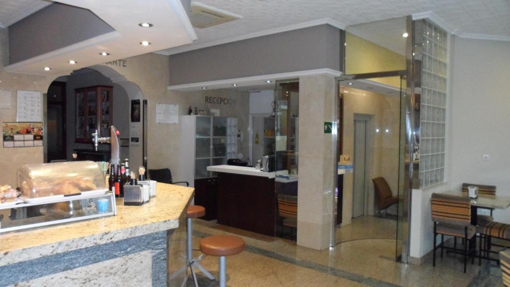 a restaurant with a counter and a bar in a room at Hostal Coruña in Astorga