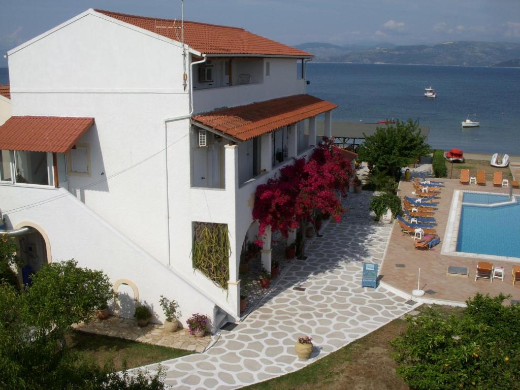 a building with a swimming pool next to a house at Likourgos Beach in Kavos