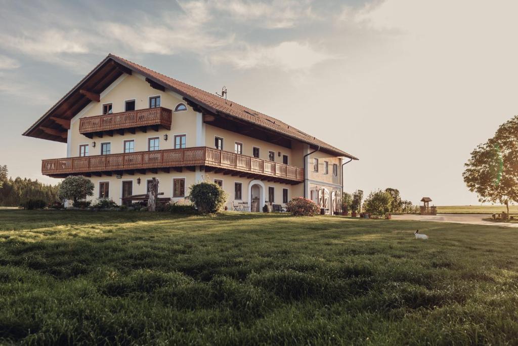 a large house in a field with a grassy field at Chalet-Apartments Am Schmiedhof in Vogtareuth