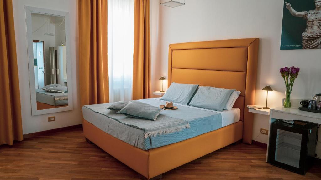 una camera da letto con un letto con una grande testiera e uno specchio di TIBERIM Exclusive Rome a Roma