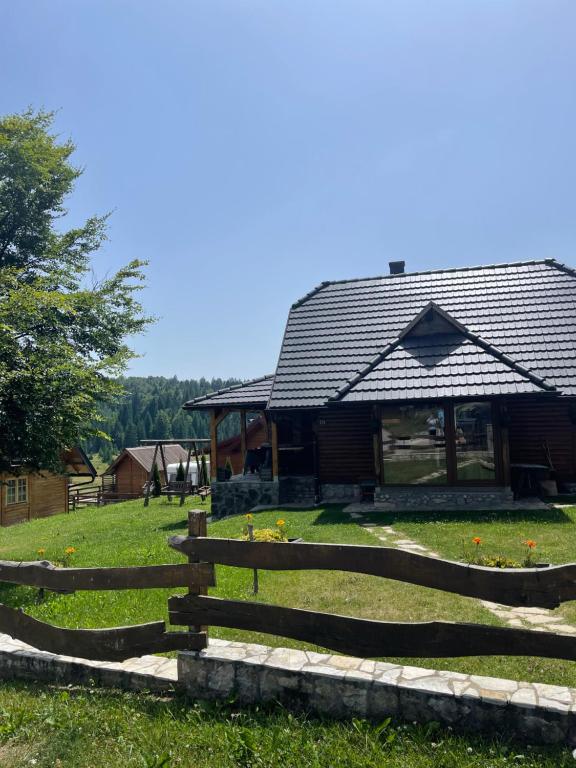 a wooden barn with a fence in front of it at Brvnare Sekulic in Sekulić 