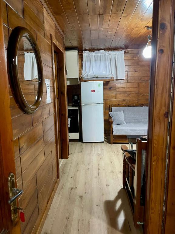 a small kitchen with a refrigerator and a mirror at Guest House DEA in Vlorë