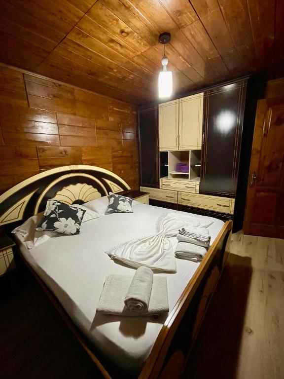 a bedroom with a large bed in a wooden room at Guest House DEA in Vlorë