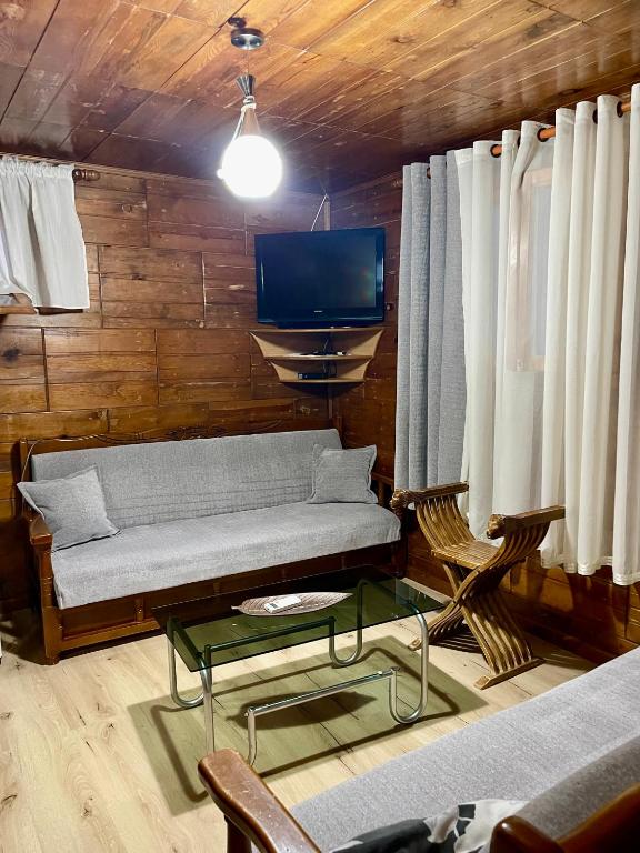 a living room with a couch and a tv at Guest House DEA in Vlorë