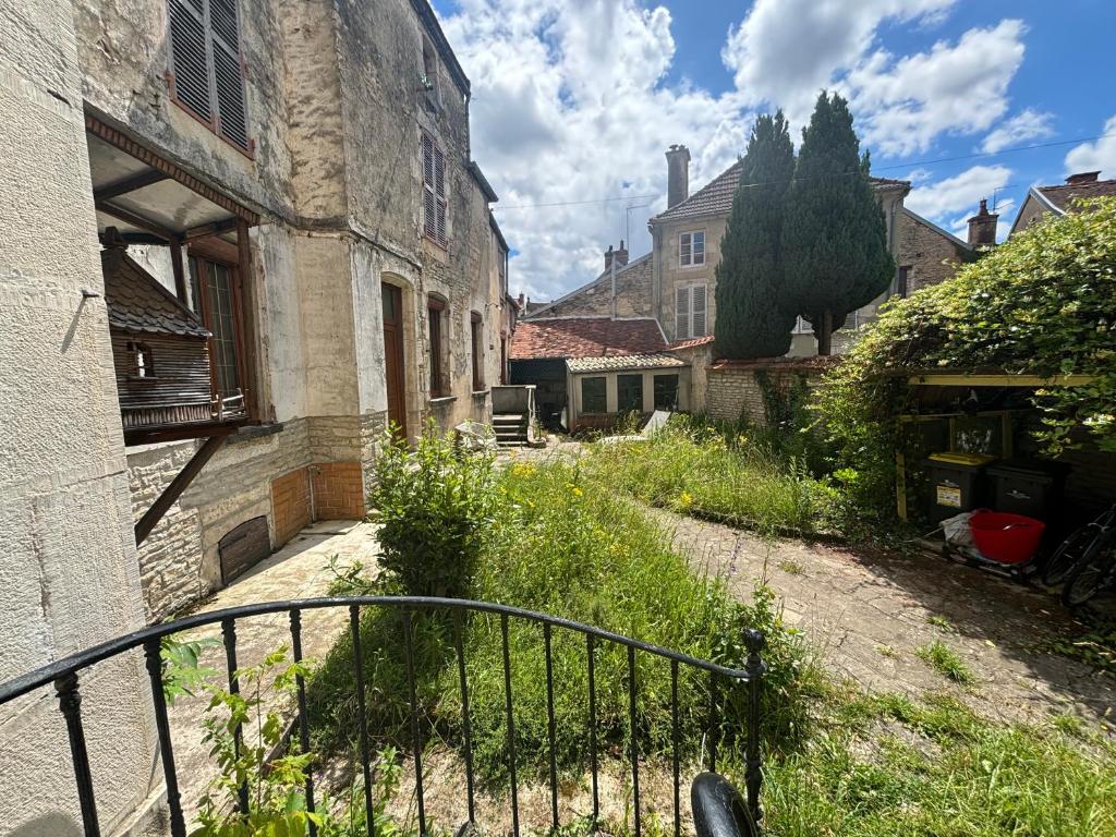 un vieux bâtiment avec une porte à côté d'une rue dans l'établissement Le Petit Saint Vorles, à Châtillon-sur-Seine