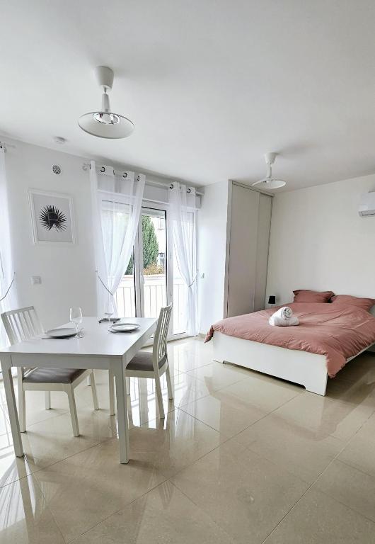 - une chambre avec une table, un lit, une table et des chaises dans l'établissement Charmant studio 