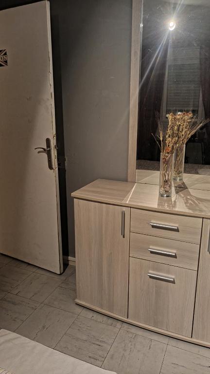 a wooden cabinet with a vase of flowers on it at Apartamento de ferias in Bezons