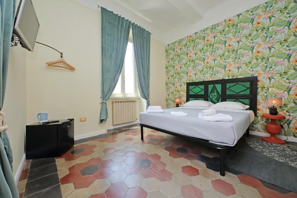 a bedroom with a bed in a room with floral wallpaper at Colosseo Kokedama rooms in Rome