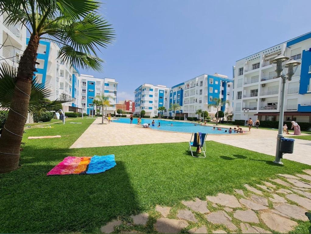 a kite laying on the grass next to a swimming pool at martil in Martil