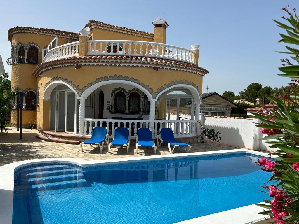 a villa with a swimming pool in front of a house at COLOMBIA piscina privada in Miami Platja