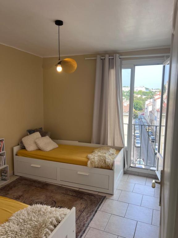 a bedroom with a bed with a large window at Magnifique appartement avec une très belle vue in Marseille