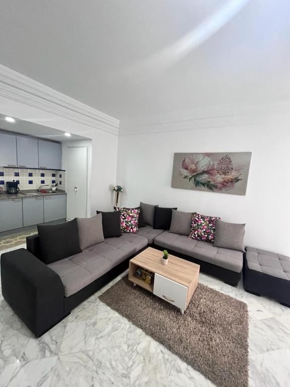 a living room with a couch and a coffee table at Appartement slim centre sousse in Sousse