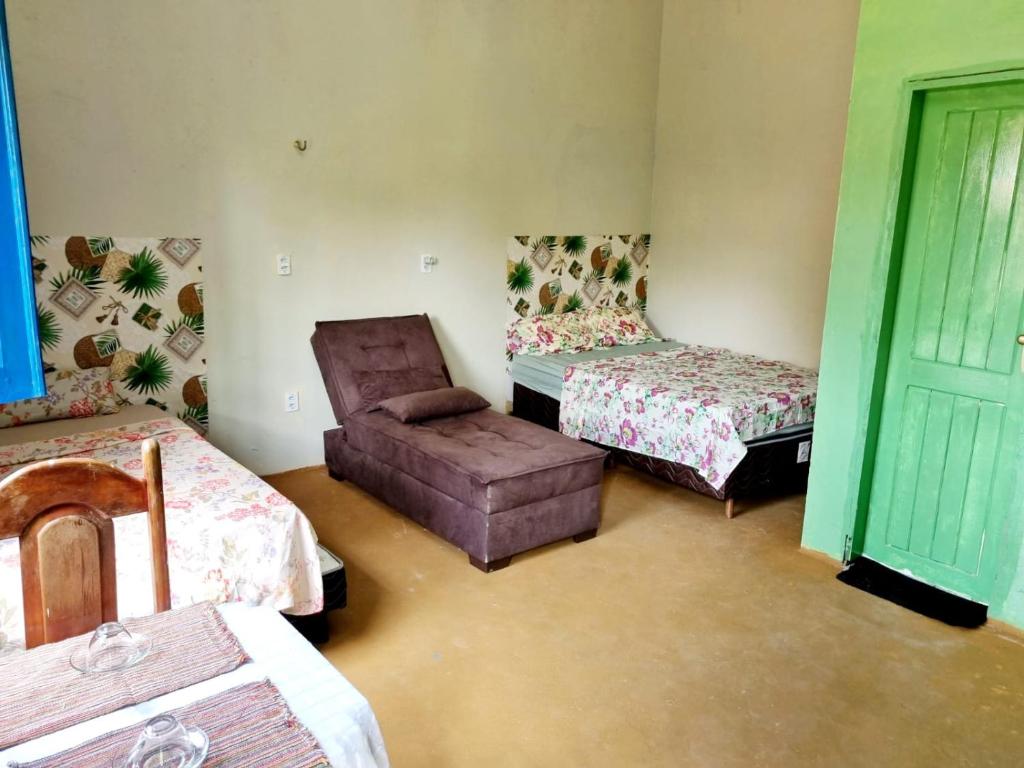 a room with two beds and a chair and a couch at Suíte estrela do sal in Salinópolis