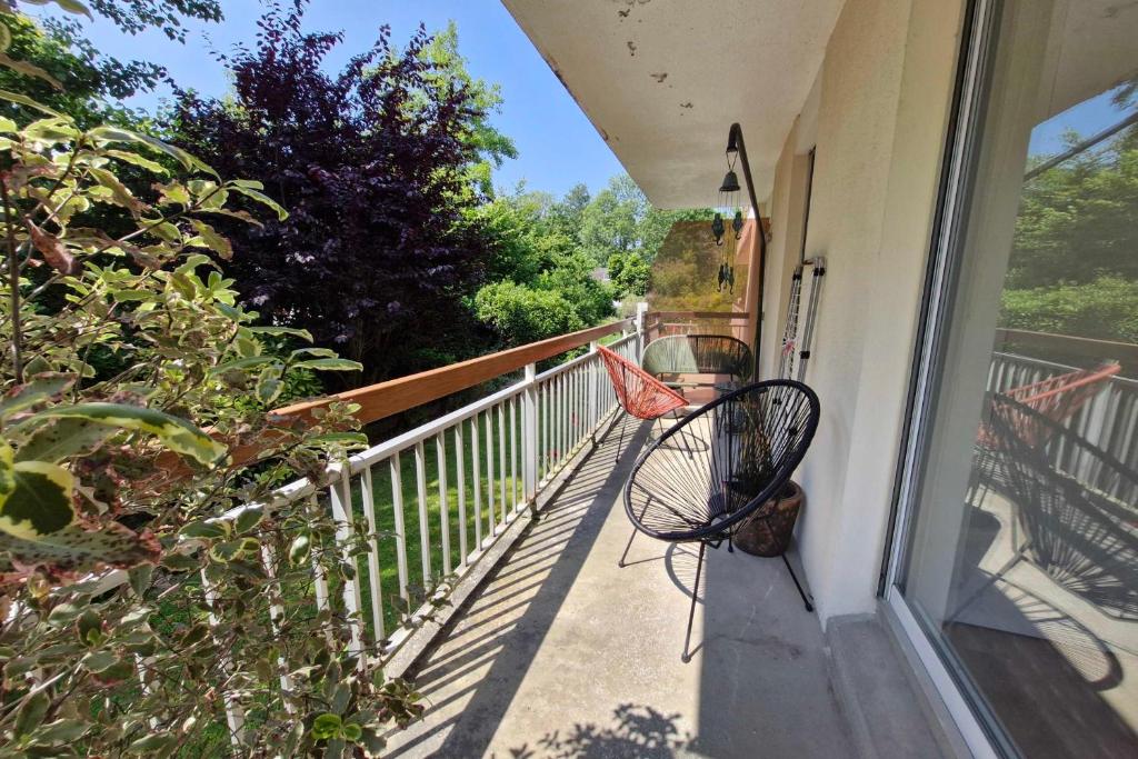a chair sitting on the porch of a house at Family apartment near the sea of Houlgate in Houlgate