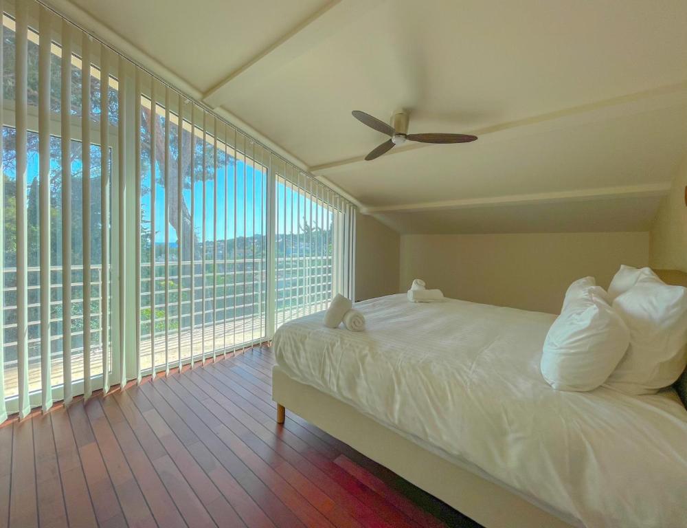 une chambre avec un lit et un ventilateur de plafond dans l'établissement Villa Helric dans Cassis - Jardin - Parking, à Cassis