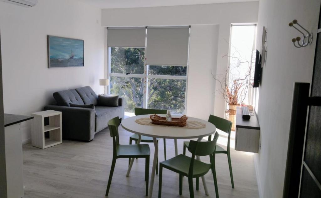 Una sala de estar con una mesa y sillas y un sofá. en Wales Ave. Apartment, en Puerto Madryn