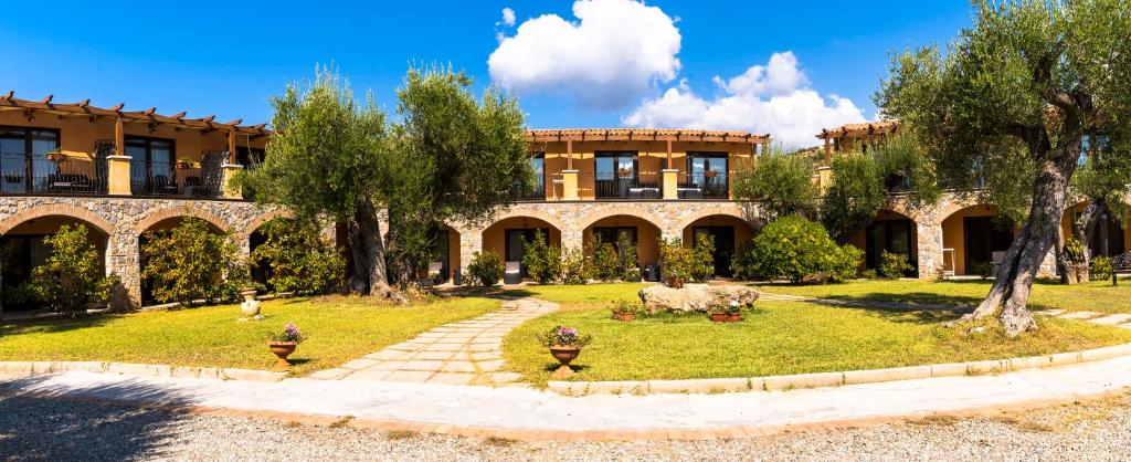 a building with a yard with animals in front of it at Park Hotel Cilento in Marina di Camerota