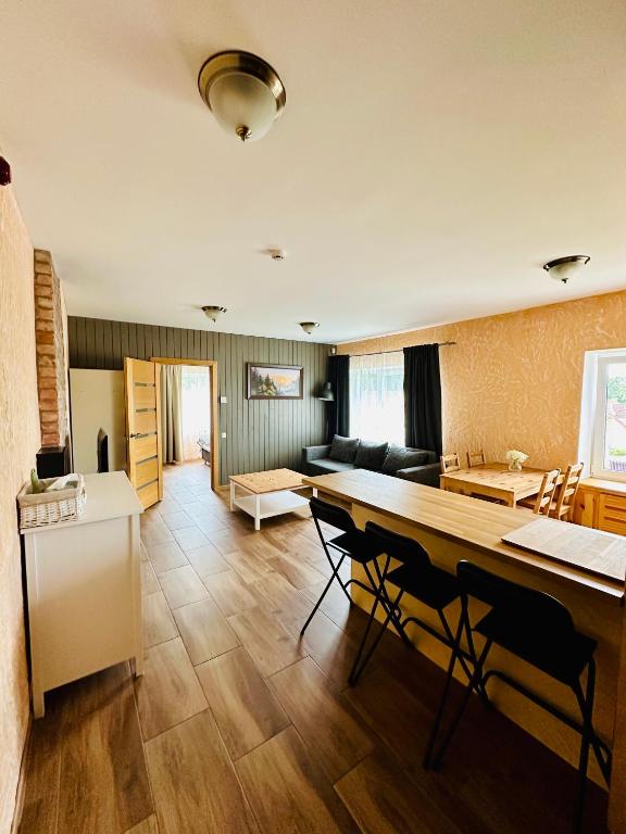 a kitchen and living room with a long table and chairs at Rožu namu apartamenti 2 in Kuldīga