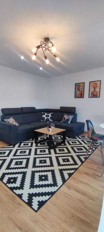 a living room with a couch and a table on a rug at Apartament Lubin in Lubin