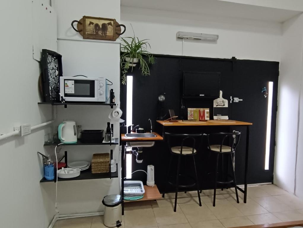 cocina con encimera con taburetes y microondas en Estudio Villa Crespo, en Buenos Aires
