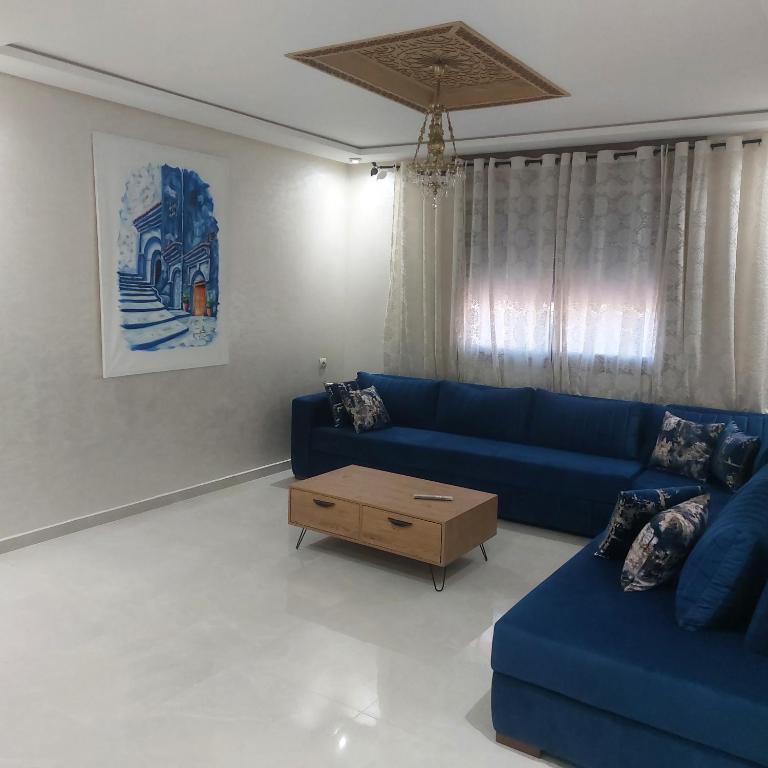 a living room with a blue couch and a coffee table at Stylish Home, Mountain View, Netflix, Wifi in Chefchaouene