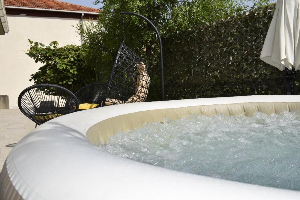 a hot tub in a backyard with a bird net at Romantic Escape With Private Hot Tub Near Split in Žrnovnica