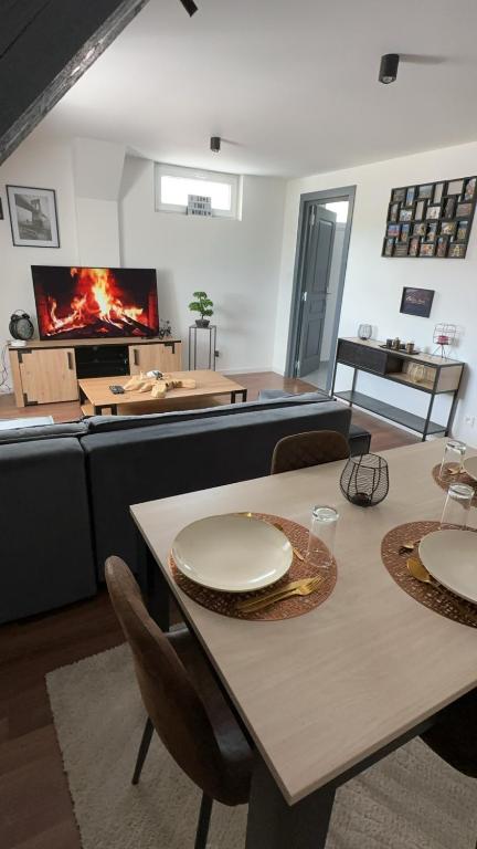 un salon avec une table et une cheminée dans l'établissement Le petit Riquewihr, à Riquewihr