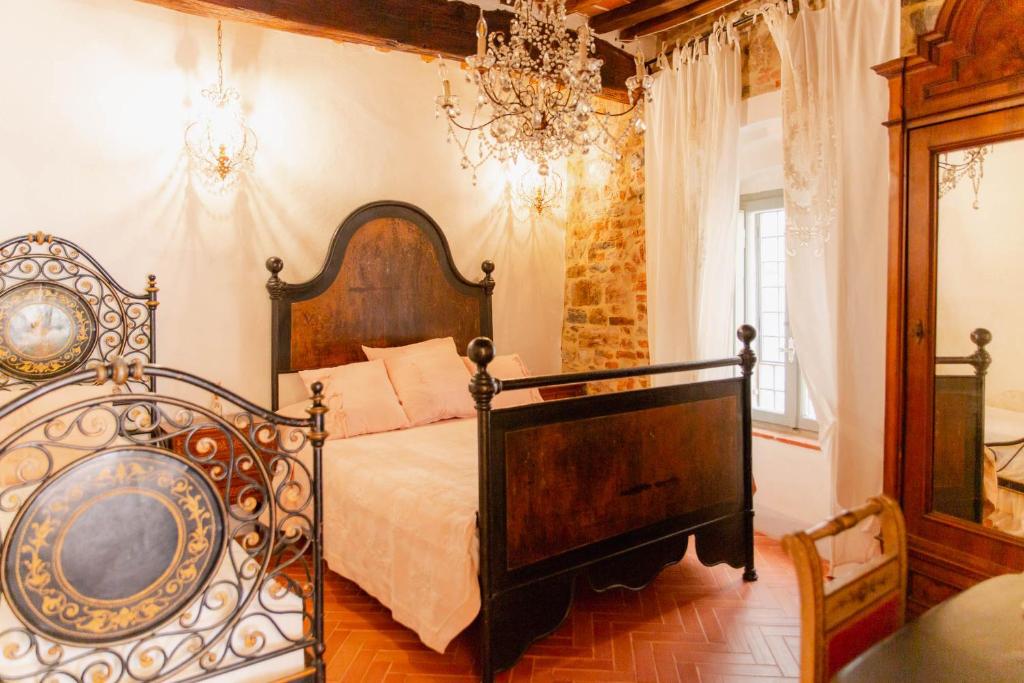 sypialnia z łóżkiem i żyrandolem w obiekcie Casa Raffaella 1 Tuscan charm in medieval Suvereto w mieście Suvereto