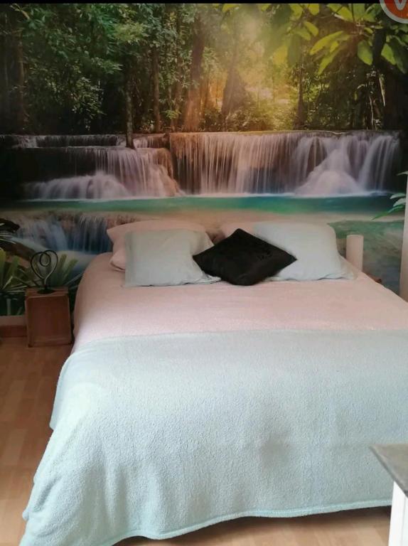 - une chambre avec un lit en face d'une fresque murale représentant une cascade dans l'établissement chambre atypique entre mer et collines, à Belgentier
