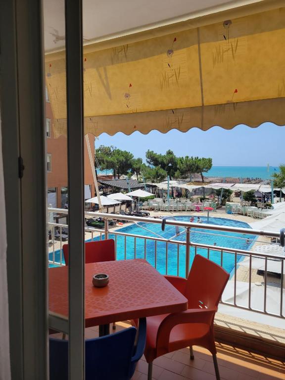 a balcony with a table and chairs and a swimming pool at Bella Vista Durazzo in Golem