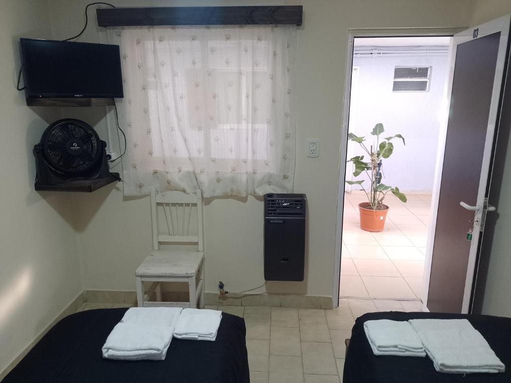 a room with two beds and a television and a window at Hotel Parque in Villa Mercedes