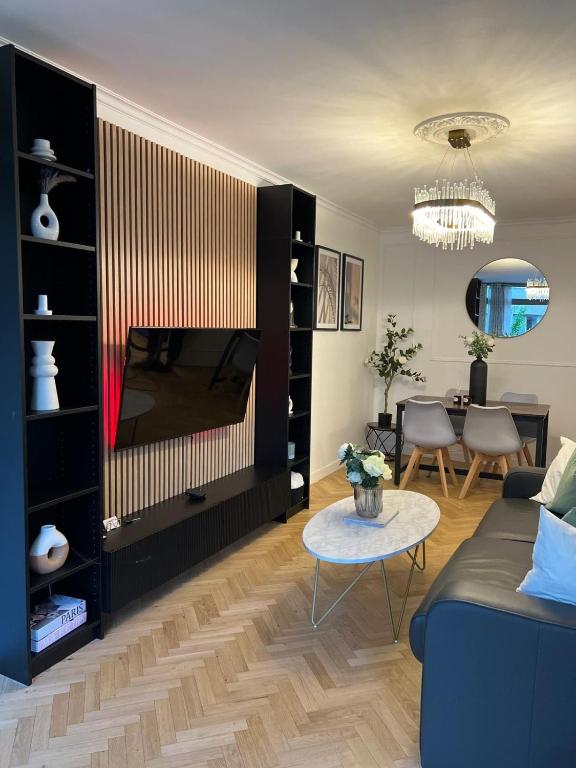 un salon avec un canapé et une télévision dans l'établissement Excellent Apartment for Familly, à Clichy