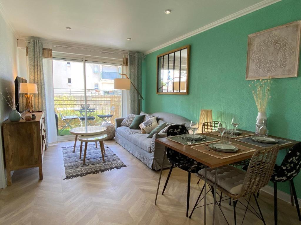 un salon avec un canapé et une table dans l'établissement Chaleureux deux pièce coeur de ville avec parking privé, à Cabourg