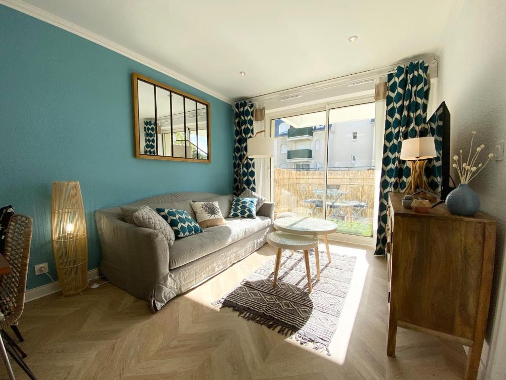 un salon avec un canapé et une table dans l'établissement Cosy deux pièces coeur de ville avec parking privé, à Cabourg