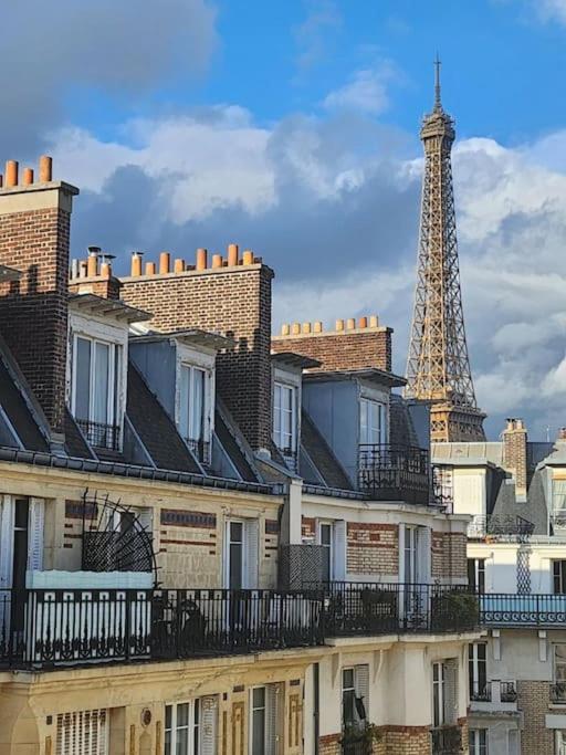 un groupe de bâtiments avec la tour Eiffel en arrière-plan dans l'établissement Elegant Eiffel tower view flat, à Paris