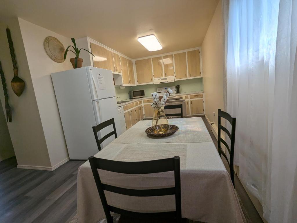 a kitchen with a table with chairs and a white refrigerator at Fireweed Apartments in Fairbanks
