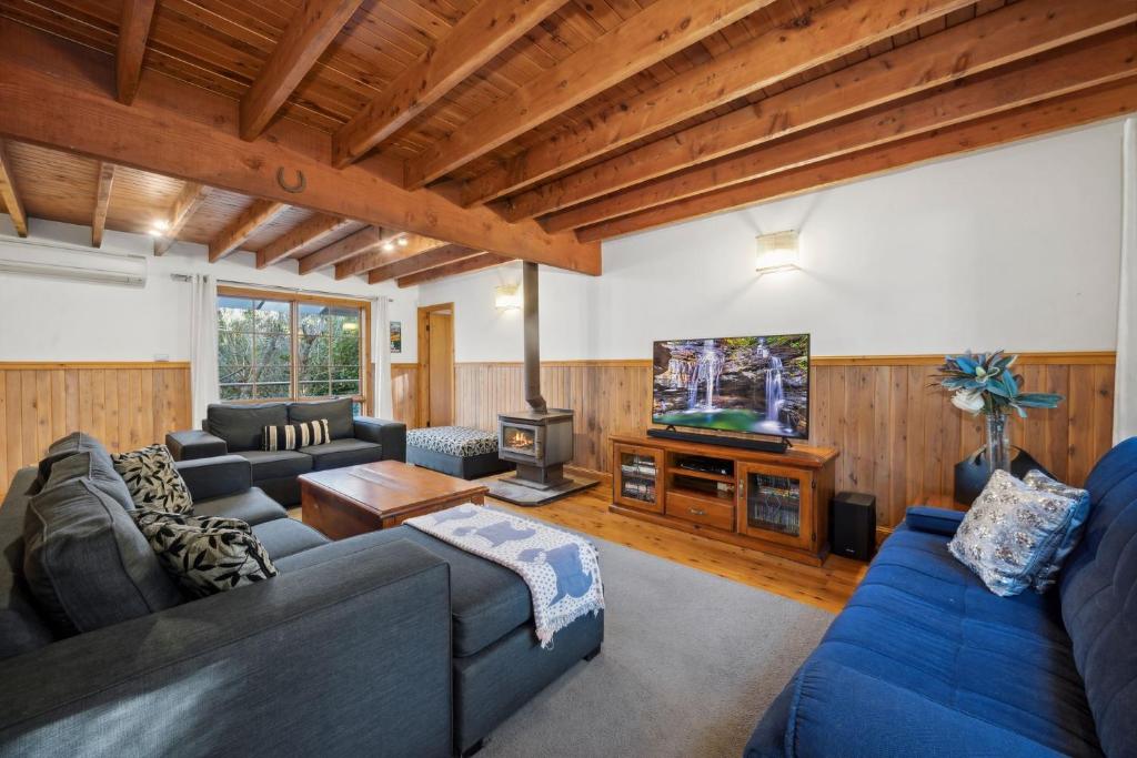 Una sala de estar con sofás y un televisor. en Our Glenbogle, en Medlow Bath