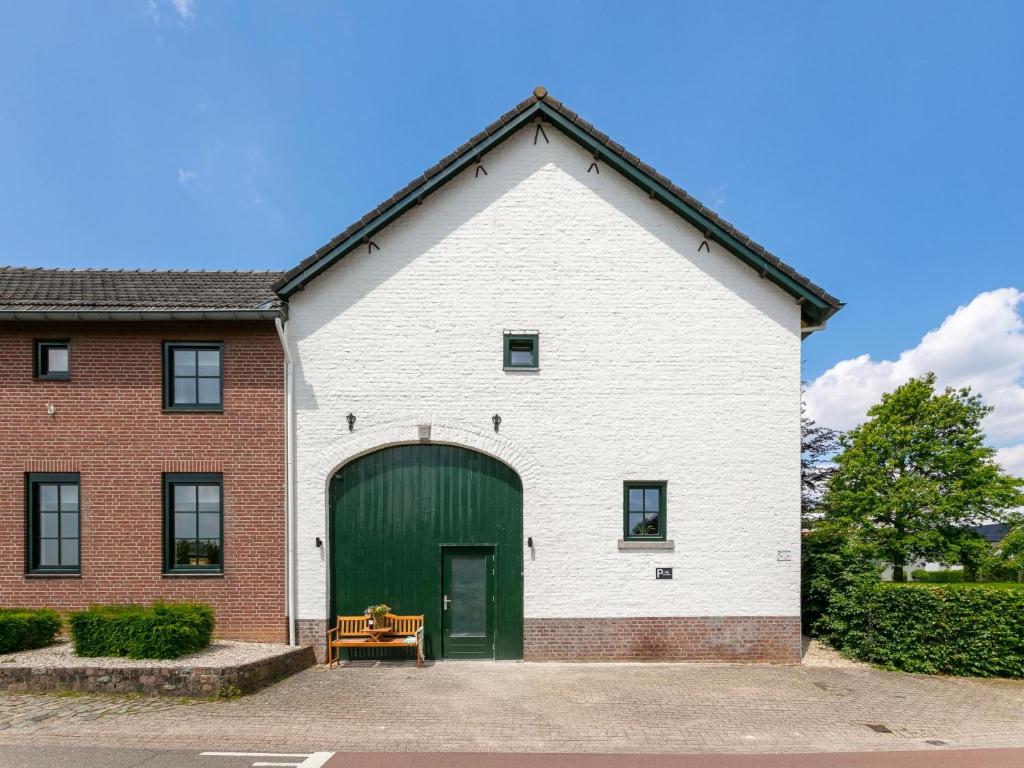 a large white building with a green garage at Heimerhöfkes -2 in Klimmen