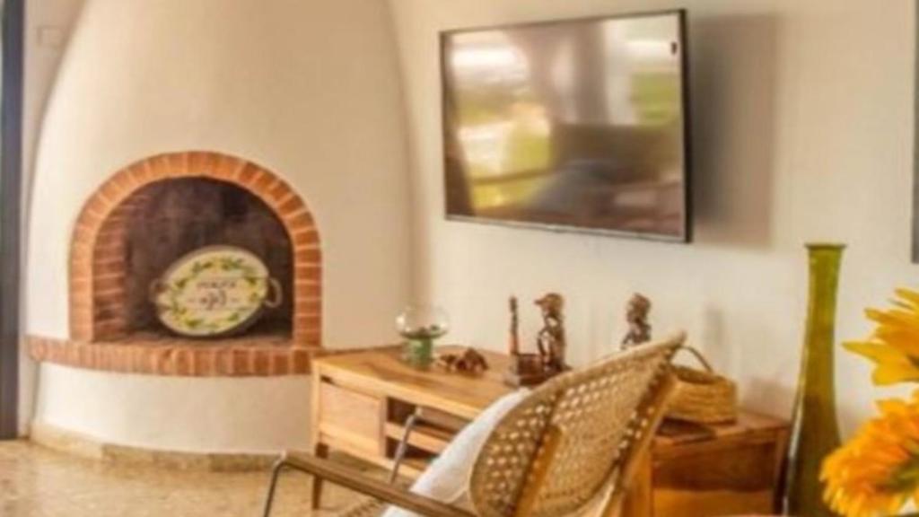 a living room with a table and a fireplace at New Villa Es Novells Illes Balears in Illes Balears