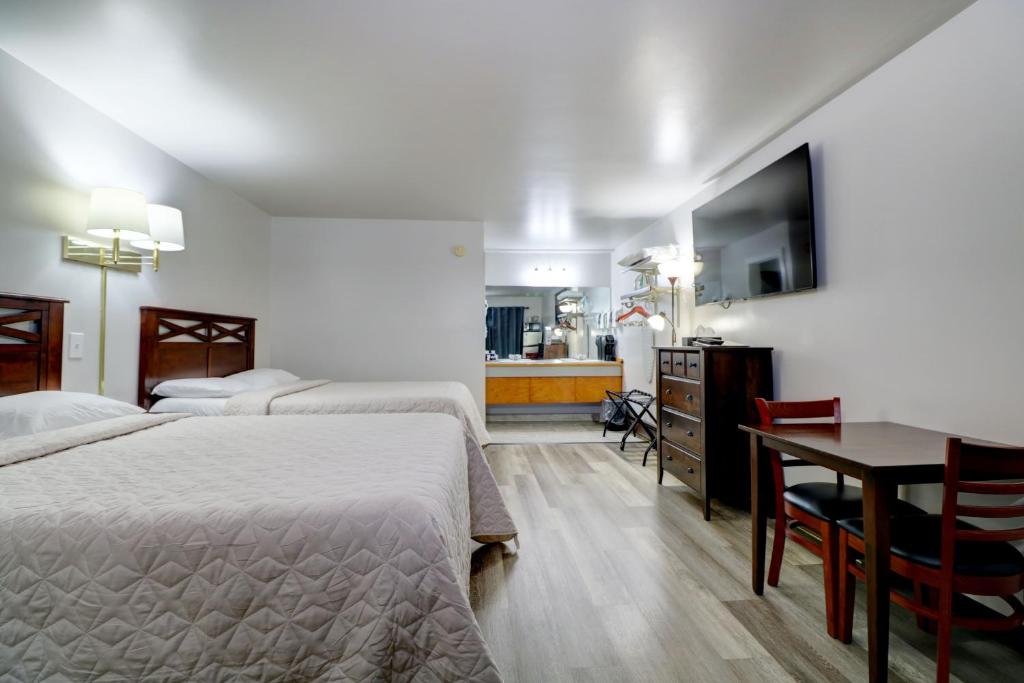 a hotel room with two beds and a table and a kitchen at Canaan Motel in Canaan
