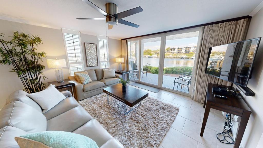 Una sala de estar con un sofá blanco y un televisor. en Dolphin Point 105B- by Holiday Isle Properties, en Destin