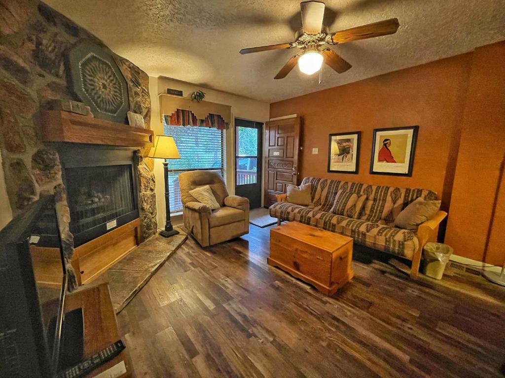 un soggiorno con divano e camino di Valley Condo 107 - Creekside - WiFi - Hot Tub - Fireplace - Washer - Dryer - Playground a Red River