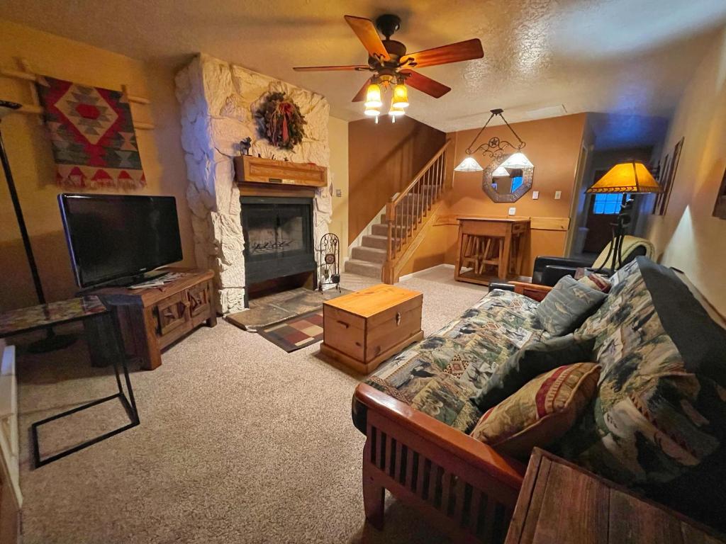 un soggiorno con divano e camino di Valley Condo 110 - Creekside - WiFi - Pet Friendly - Hot Tub - Fireplace - Washer - Dryer - Playground a Red River