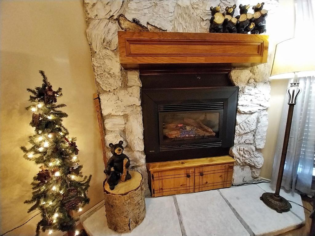 un soggiorno con camino e albero di Natale di Valley Condo 111 - Dancing Bear Retreat - Creekside - WiFi - Hot Tub - Fireplace - Washer - Dryer - Playground a Red River