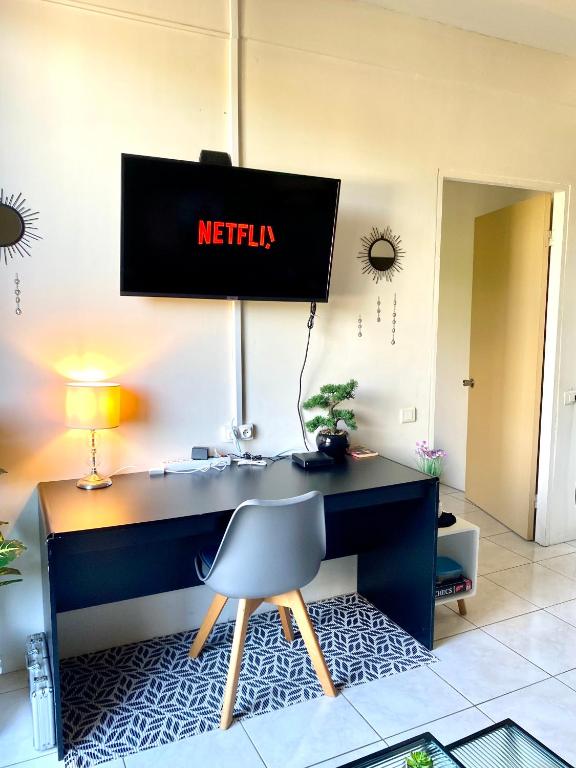 an office with a desk with a television on the wall at Heiata Lodge Papeete in Papeete