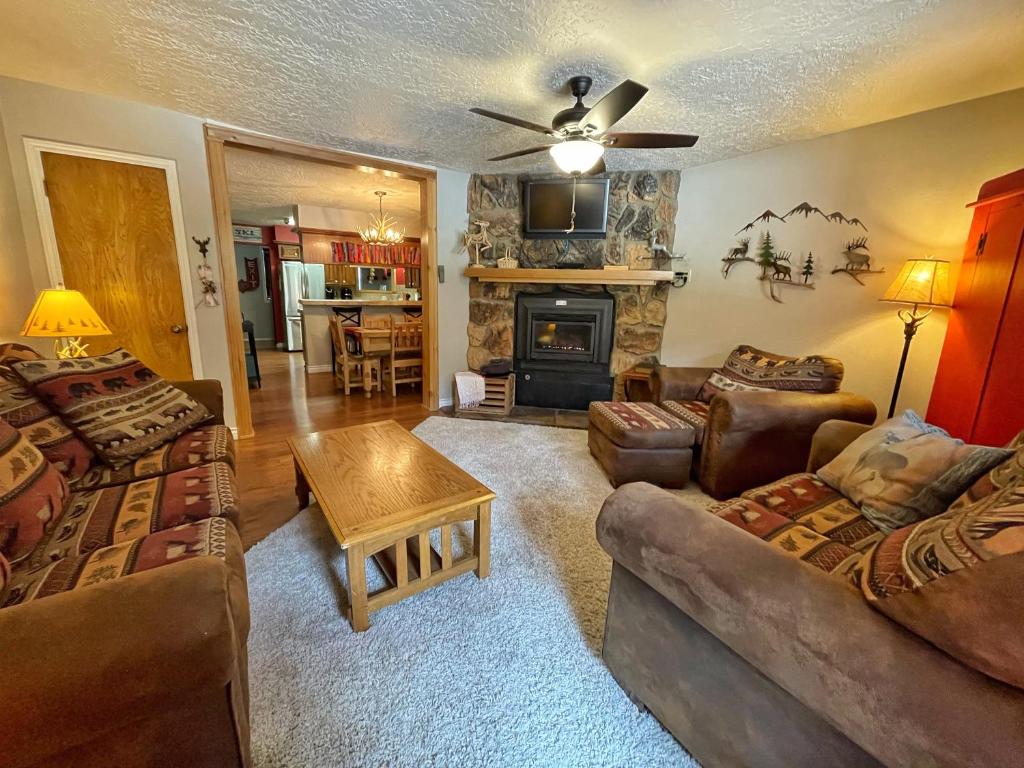 un soggiorno con due divani e un camino di Valley Condo 120 - Creekside - WiFi - Pet Friendly - Hot Tub - Fireplace - Washer - Dryer - Playground a Red River