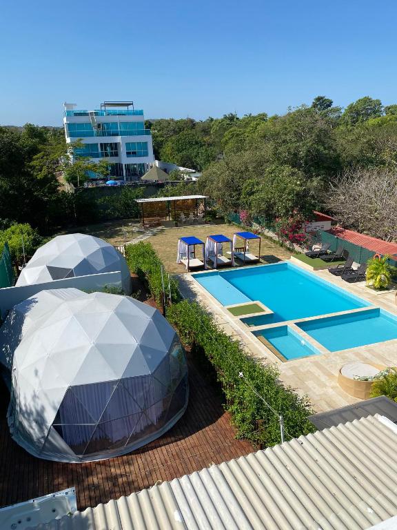 a swimming pool with two domes next to a building at Hotel Aqua House in Tubará