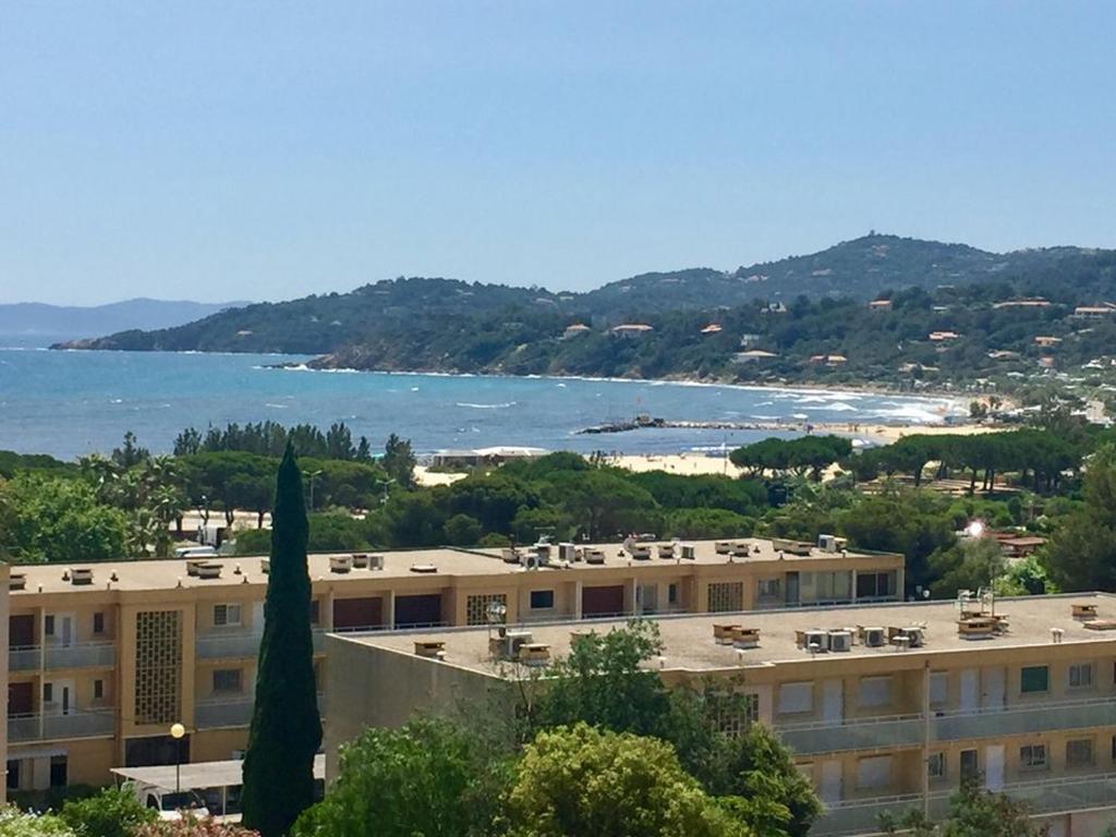 - une vue sur un bâtiment avec une plage en arrière-plan dans l'établissement T2 climatisé proche plage avec garage, Bormes-les-Mimosas - FR-1-803-29, à Bormes-les-Mimosas