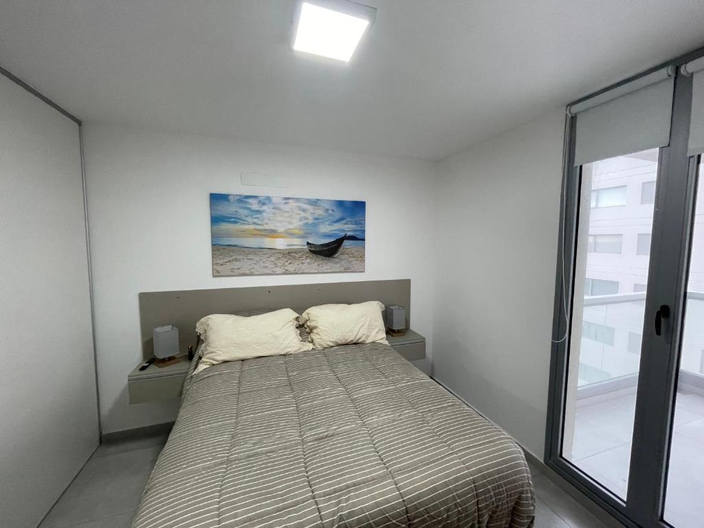 un dormitorio con una cama y una ventana en Torres al Mar, en Monte Hermoso